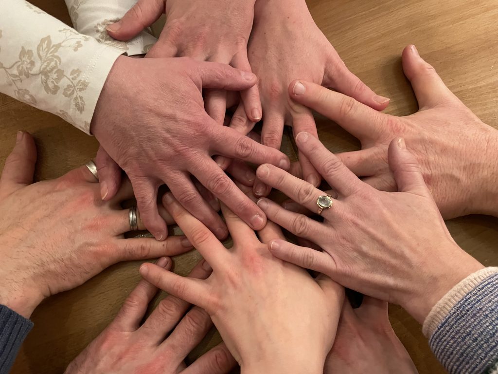 Mehrere Hände übereinander als Sinnbild für partnerschaftliche Zusammenarbeit_Foto_UW