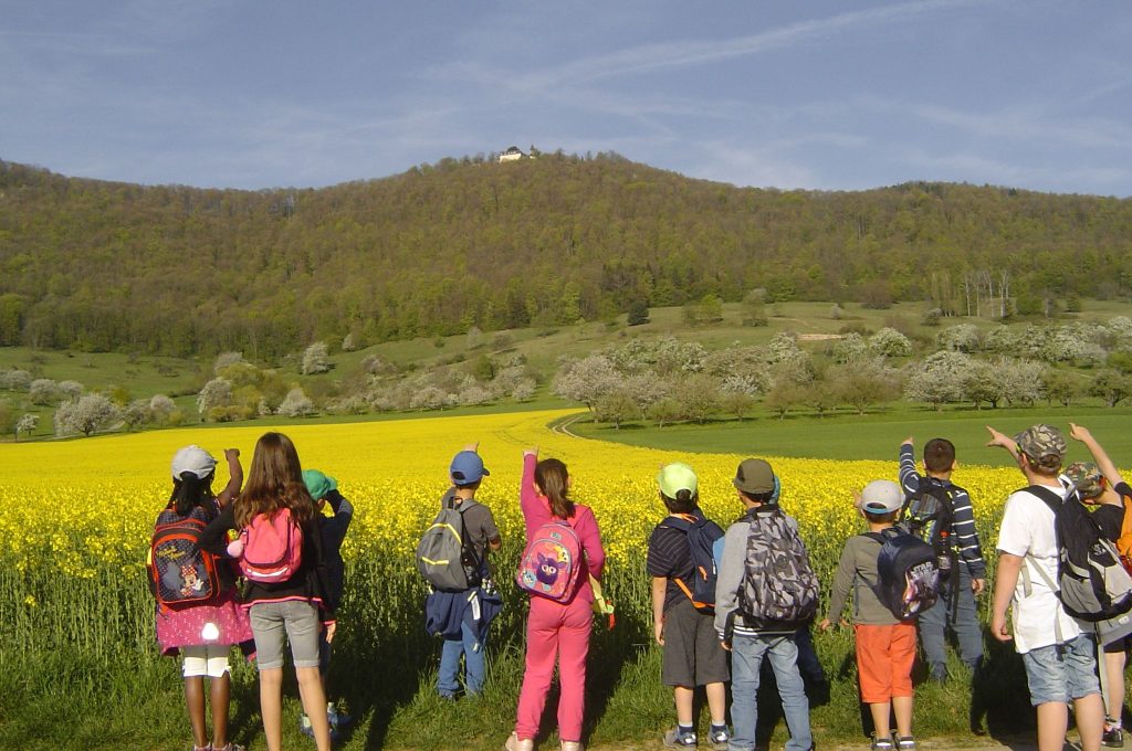 Schulklasse beim Wandern mit Blick auf die Schwäbische Alb